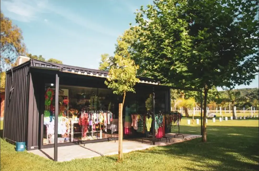 Loja de utilidades com vitrine de roupas e artigos de piscina, no gramado